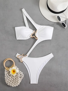 Flat lay of white one-shoulder monokini featuring gold asymmetrical metal ring buckle details