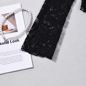 Close-up of intricate black floral lace cuffs and delicate crochet texture on the top