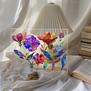Close-up of a floral acrylic desktop plaque with a wooden base on a white fabric surface