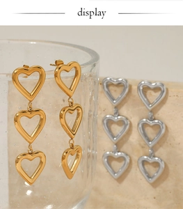Vue détaillée des boucles d'oreilles triple cœur en acier 316 doré et argenté poli