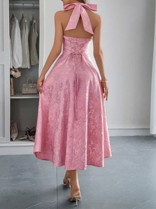 Dettaglio dell'elegante abito rosa con scollo all'americana e fiocco sulla schiena