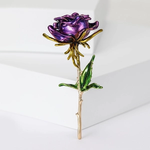 Detailed view of a purple enamel rose brooch with golden stem and green leaves