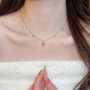 Close-up of a silver necklace with sparkling zircon cross pendants on a model neck