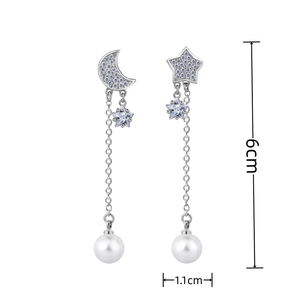 Detailed view of silver star and moon earrings with pearls, showing 6cm total length