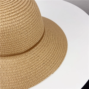 Close-up of the woven straw texture and decorative ribbon on the beige sun hat