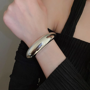Polished silver irregular wide cuff bracelet with mirror finish on model wrist