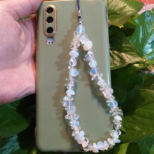 Detail of bohemian phone strap made of clear and blue natural crushed stone beads