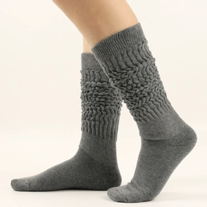 Detailed texture of gray knit slouch socks with thick wave-like ribbed layers