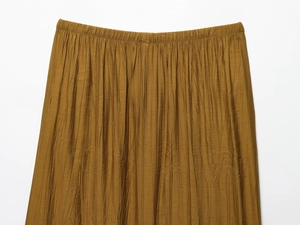 Detail of caramel pleated skirt featuring elastic waistband and fine crinkle texture fabric
