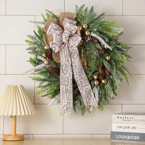 Christmas wreath with pine cones and golden bells on rustic burlap ribbon decoration