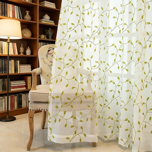 Detail of white sheer curtain with green leaf embroidery in a cozy French style room