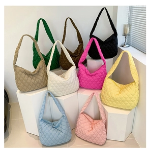 Collection of quilted puffer tote bags displayed in nine vibrant colors on white pedestals