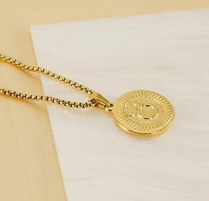 Détail du pendentif zodiaque Taureau en or 18 carats avec une chaîne à mailles box