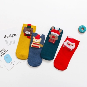 Quatre paires de chaussettes de Noël en coton avec motifs 3D sur fond blanc épuré