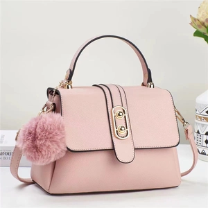 Pale pink lychee grain faux leather handbag with gold clasp and plush pom pom pendant