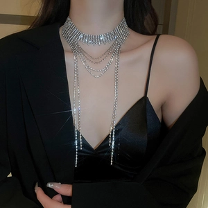 Primo piano della collana choker con nappe di strass indossata su un abito nero