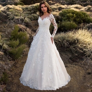 Elegant white long sleeve lace bridal gown with A-line skirt and floral embroidery