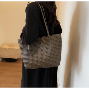 Detailed view of large taupe woven tote bag with shoulder straps for women