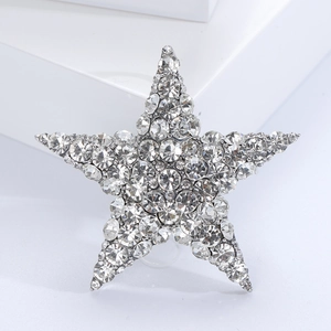Detailed close-up of a sparkling star brooch with clear rhinestones on a white pedestal