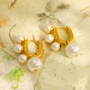 Boucles d'oreilles en acier inoxydable doré 18 carats avec perles sur papier artistique