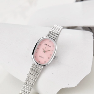 Detailed macro view of the silver oval quartz watch with a soft pink sunray dial