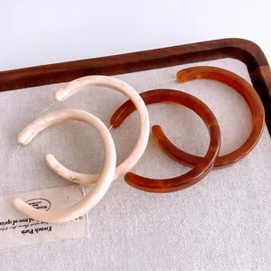 Retro resin C-shaped hoop earrings in cream marble and tortoise shell patterns