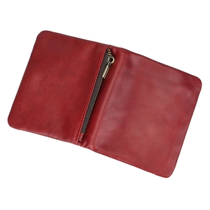 Detail of red leather wallet interior with textured surface and metal zipper compartment