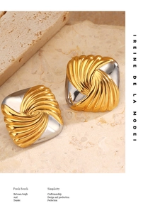 Detail of square geometric earrings in two-tone gold and silver with twisted texture