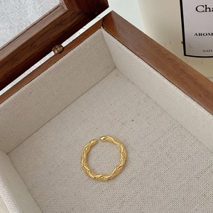 Detail eines goldenen Vintage-Kordelrings auf einer Samtpolsterung in der Schmuckschatulle
