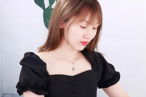 Detail of elegant silver heart pendant necklace shown on a female model neck
