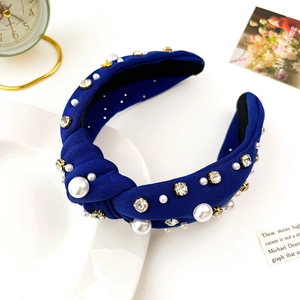 Detail of luxury royal blue knotted headband with white pearls and sparkling rhinestones