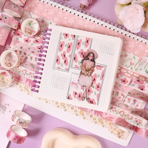 Pink washi tape set with floral patterns and cute notebook for DIY journaling and crafting.