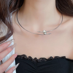 Detail of silver arrow choker necklace featuring a central oval-cut sparkling zircon stone