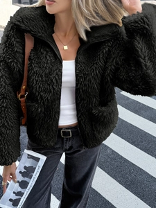 Close-up of black teddy fur jacket featuring casual zipper style and soft plush texture
