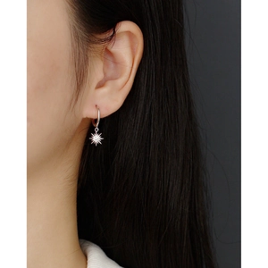 Close-up of S925 sterling silver sun-shaped hoop earrings with sparkling zircon on ear