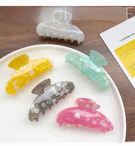 Detailed view of colorful acetate hair claws with marble texture on a wooden surface