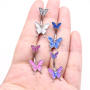Set of butterfly belly rings in four colors shown on a palm for size reference
