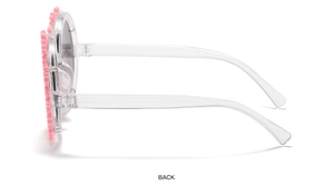 Side view of pink flower-shaped children sunglasses with transparent plastic temples