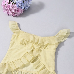 Flat lay of pale yellow ruffled strapless top with crinkle texture and floral decor