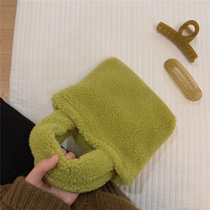 Détail d'un mini sac à main en laine d'agneau vert vif avec une texture douce et pelucheuse