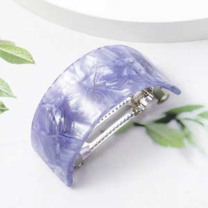 Macro detail of purple and white marble acetate hair claw clip with metal spring