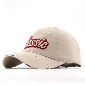 Detail of khaki cotton baseball cap with classic embroidery and distressed frayed edges