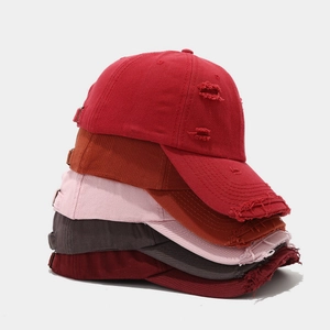Detailed stack of distressed cotton baseball caps with vintage ripped edges and metal buckles