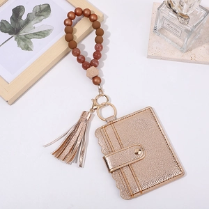Detail of gold PU leather wallet with tassel and silicone beaded wristlet keychain charm