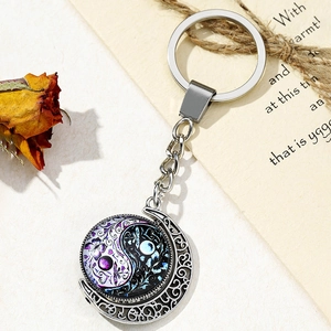 Detail of silver yin yang butterfly keychain with moon charm and glass gemstone pendant