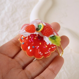 Handheld realistic strawberry donut keychain with colorful sprinkles and golden chain