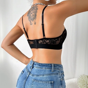 Detail of black lace bralette featuring floral embroidery and adjustable back straps