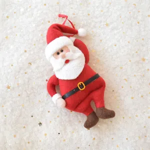 Detail of plush Santa Claus ornament with red felt suit and gold belt buckle hanging