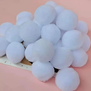 Close-up of fluffy white plush pompoms for DIY crafts and Christmas clothing decoration