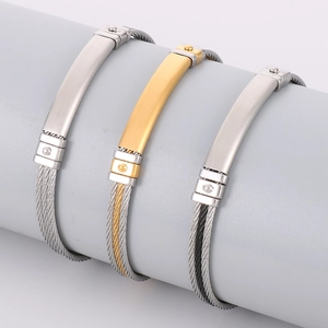 Three men's stainless steel cable bracelets in silver, gold, and black with metal plates